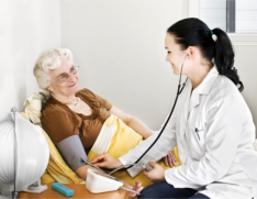caregiver checking blood pressure of elderly woman